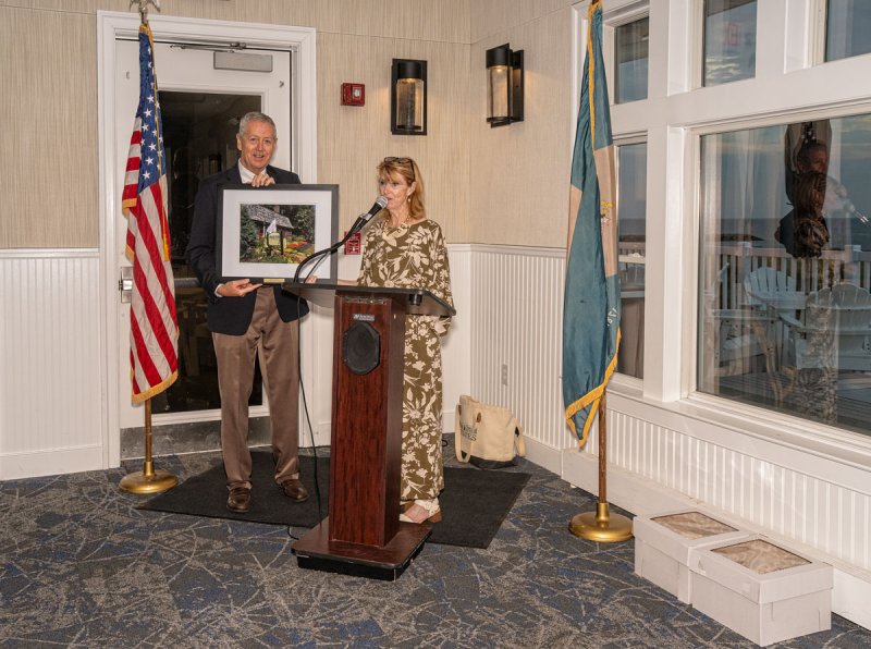 Ray Book, left, was recognized by Betsy Reamer for the completion of his term as president with a framed photograph by Brook Hedge of the Fisher-Martin House, the location of the chamber’s visitors center.